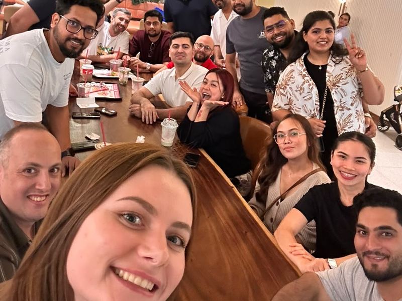 United Expats in UAE members smiling in a group selfie at a cafe